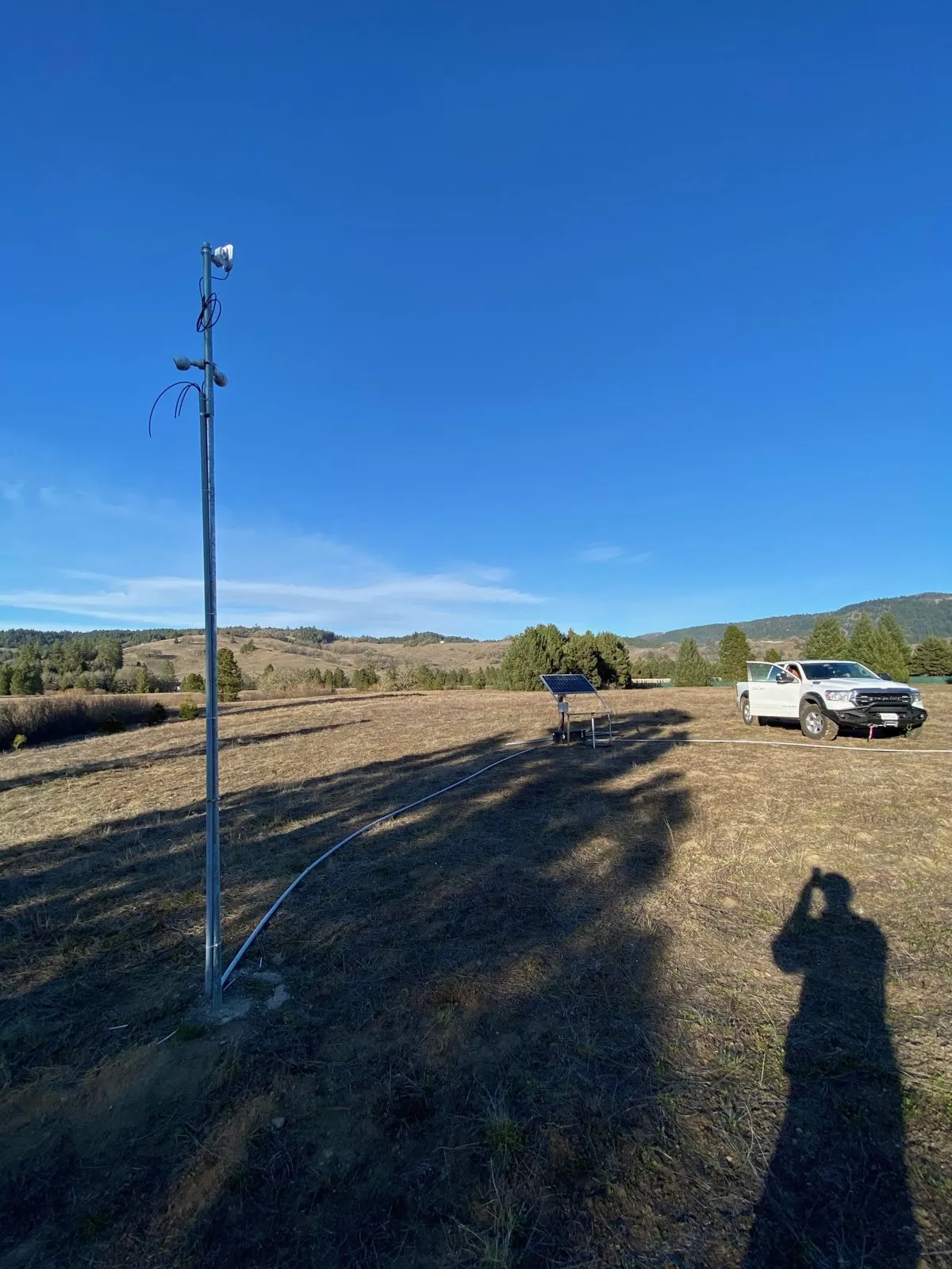 Newly installed camera pole with solar power and a point-to-point radio in a rural field