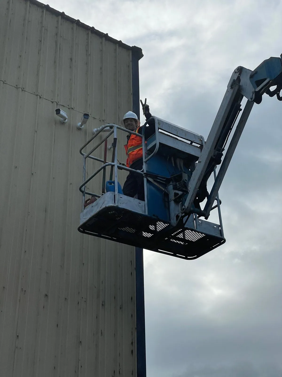 Joel Rosser installing a camera high on a building from a boom lift